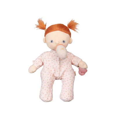 Plush toy baby doll with red hair and pink outfit on a white background