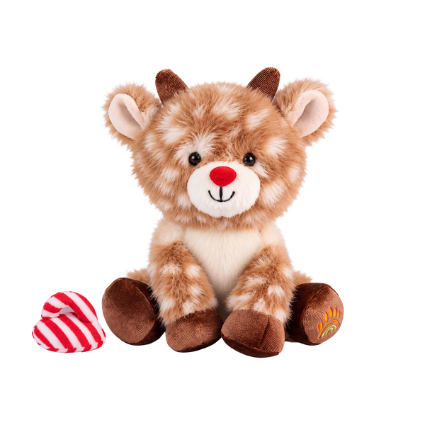 Fluffy plush reindeer with fawn fur and cream spots, a red nose, a smiling cream muzzle, short brown corduroy antlers and hooves, and an embroidered paw-and-rainbow motif on one foot, sitting beside a red and white striped hat.