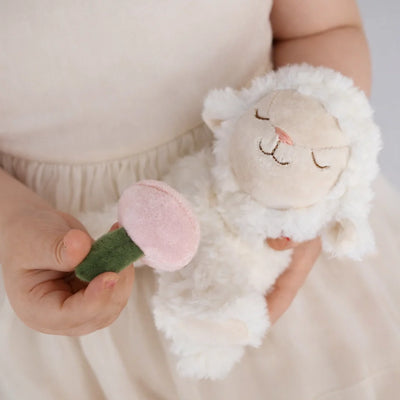 Binky Lamb - May plush lamb held by a child beside a soft pink felt flower from Dinkum Pets