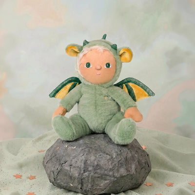 Dinky Dinkum - Dax Dragon soft doll in a green dragon costume with yellow wings and horns seated on a rock. Dinky Dinkums plush toy for imaginative play