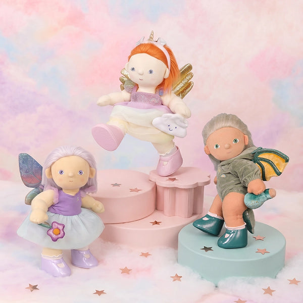 Three fairy figurines on colorful stands with a pastel background