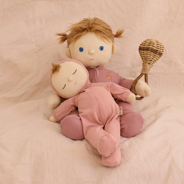 Dozy Dinkums - Moppet soft baby doll cuddled by a larger doll holding a wooden rattle on a soft pink backdrop for imaginative play