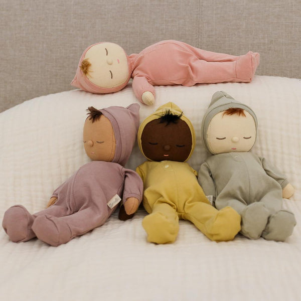 Dozy Dinkums - Moppet soft doll shown with three cuddly baby dolls on a bed in pastel outfits for imaginative play and gentle cuddles