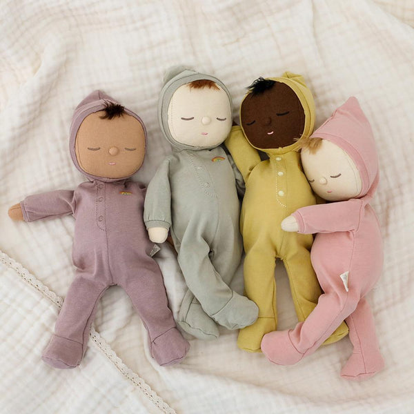 Dozy Dinkums - Moppet soft doll pictured with three other baby dolls in pastel cotton outfits on a quilted bedspread for cuddly imaginative play