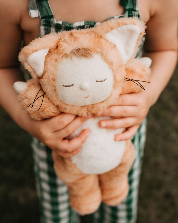 Little girl playing with ginger tabby cat, soft plush toy doll for kids
