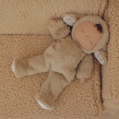 Cozy Dinkums - Lamby Pip by Dozy Dinkums cuddly plush lamb doll in a soft fluffy suit lying on a textured beige blanket