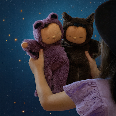 Cozy Dinkum - Bat Ozzie purple bat soft doll held beside a brown bat plush doll against a starry night backdrop