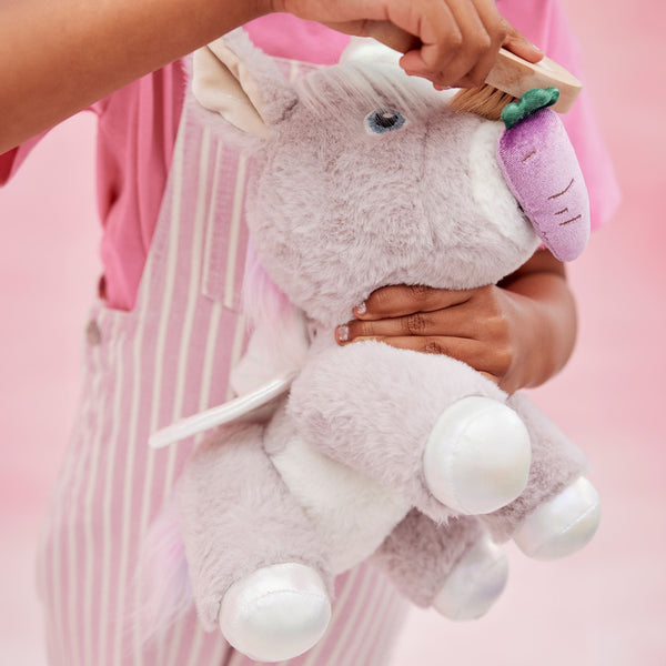 Dinkum Unicorn - Glimmer lilac plush unicorn toy with soft fur silver hooves and purple snout held by a child Dinkum Unicorns soft toy