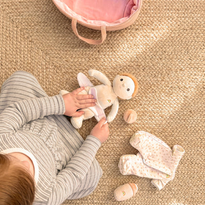 Child playing with a plush toy on a textured floor