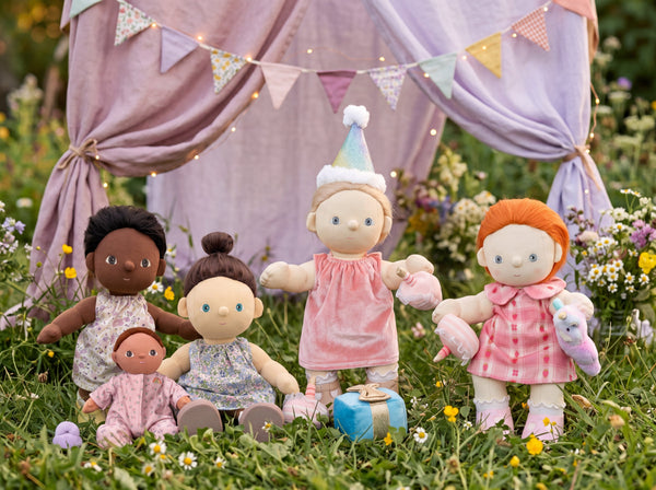 Set of dolls with different hairstyles and outfits in a garden setting with a purple tent and flags.