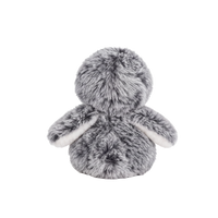 Fluffy plush penguin with grey speckled fur, a white face and tummy, black eyes, and an orange beak and feet, sitting beside a small cream fabric snowball embroidered with a blue snowflake.