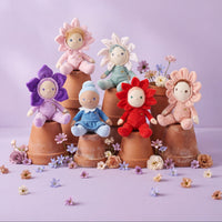 Colorful flower-shaped dolls on terracotta pots with a light purple background
