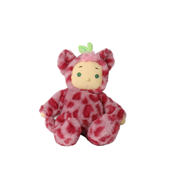 A plush toy doll with a round beige face, green eyes, and a fuzzy pink and red spotted outfit, sitting against a plain white background.