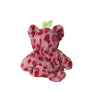 A small plush toy shaped like a bear or animal character, covered in a pink and red spotted pattern, with two small light green leaf-like accents on top, shown against a plain white background.