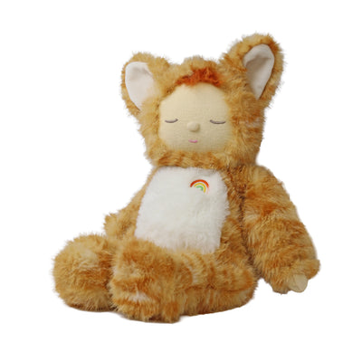 A plush teddy bear doll with orange-brown fluffy fur, a cream-colored face and belly, and a small rainbow patch on the chest, sitting against a plain white background.