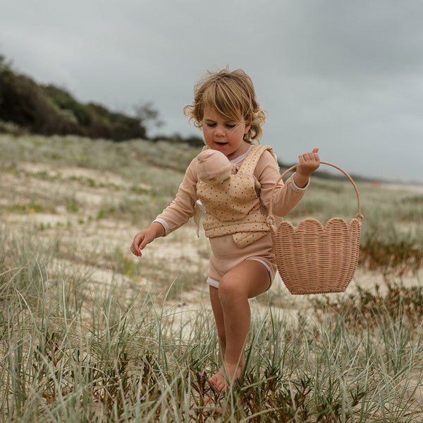 A pink polka dot doll carrier with adjustable straps, perfect for little ones to carry their favorite dolls on adventures. Ideal toddler doll accessory for imaginative parent play.
