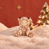 Plush doll in a fluffy fawn-print deer suit with cream spots, small brown velvet antlers and soft ears, a smooth fabric face with embroidered green eyes, and a tiny rainbow patch on the chest.