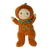 A plush Halloween doll dressed in an orange pumpkin costume with a green leaf collar and a stitched jack-o'-lantern face on the front, photographed against a plain white background.