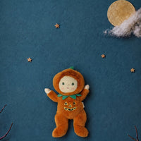A plush Halloween doll dressed in an orange pumpkin costume 