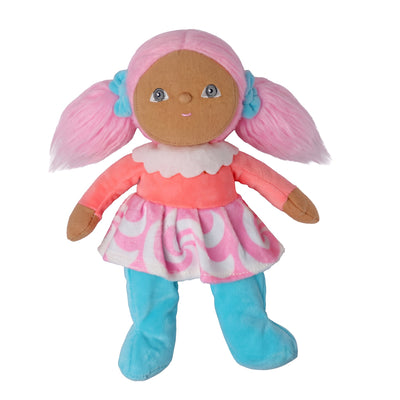 A plush doll with brown fabric skin, pink yarn hair styled in pigtails with blue bows, wearing a pink and white patterned dress and blue boot covers, isolated on a white background.