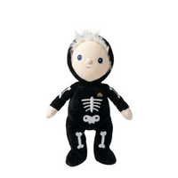 A plush toy doll dressed in a black skeleton costume with white bone graphics, a small rainbow patch on the chest, and white hair, shown against a plain white background.
