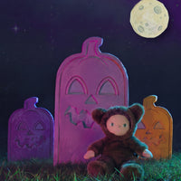 A brown plush teddy bear doll wearing a furry animal hood with small ears
