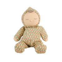 Soft baby doll with sleepy embroidered closed eyes, a smiling mouth and a tuft of brown hair, wearing a cream footed sleepsuit and matching bonnet printed with small red and green sprigs.