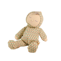 Soft baby doll with sleepy embroidered closed eyes, a smiling mouth and a tuft of brown hair, wearing a cream footed sleepsuit and matching bonnet printed with small red and green sprigs.