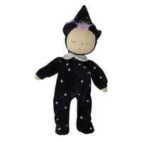 A sleeping doll dressed in a black velvet wizard costume with embroidered white stars, a small rainbow emblem on the chest, and a purple tuft of hair on a pointed hat, shown against a plain white background.