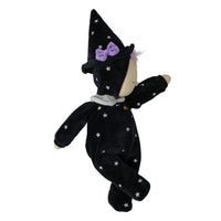 A plush baby doll wearing a black velvet witch costume with white star patterns, a purple bow on the hat, and a light beige face.