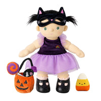 A Halloween-themed doll dressed in a purple cat costume with a black cat mask, standing next to an orange pumpkin bucket toy with a black cat inside and a small candy corn accessory, all on a white background.