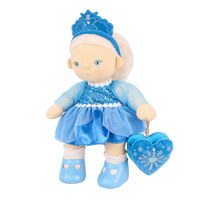 Plush doll with white hair, blue eyes and rosy cheeks, wearing a blue velvet tiara, a sequinned blue dress with sheer sparkly sleeves and a tulle skirt, white frilled socks, light blue shoes, and a blue heart-shaped bag with an embroidered snowflake.