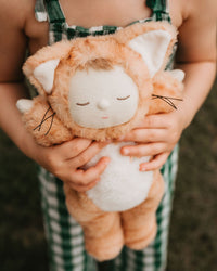 Little girl playing with ginger tabby cat, soft plush toy doll for kids