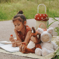 Cozy Dinkums - Fox - Finnley plush doll by Dozy Dinkums cuddled beside a child reading outdoors on a picnic blanket