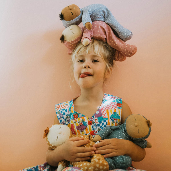 Dozy Dinkum doll with blue velvety onsie outfit. Perfectly weighted doll for calm. Plush doll with blonde hair, perfect for cuddling and interactive doll play.