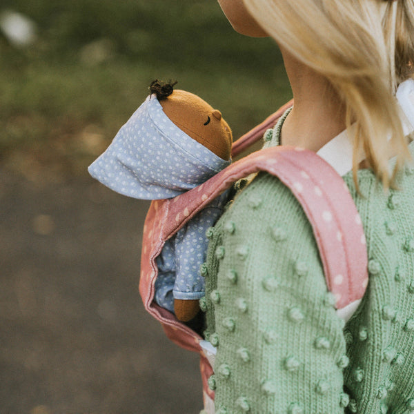 Dozy Dinkum doll with purple velvety onsie outfit. Perfectly weighted doll for calm. Plush doll with brown hair, perfect for cuddling and interactive doll play.