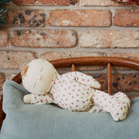Olli Ella Christmas theme Dozy Dinkum with cream print laying on bed