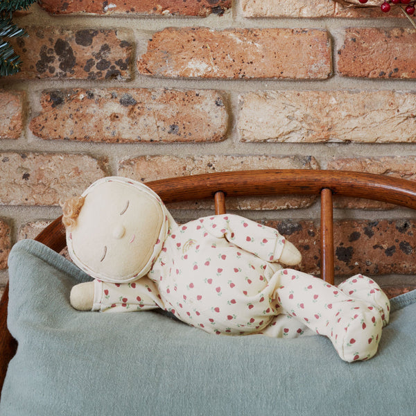 Olli Ella Christmas theme Dozy Dinkum with cream print laying on bed