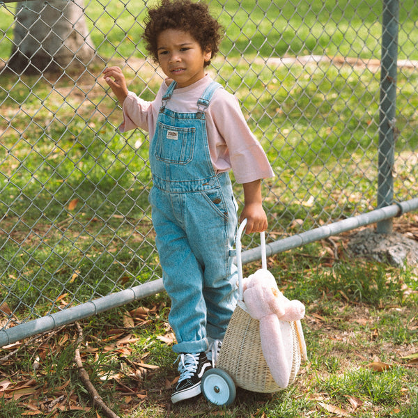 Woven rattan basket on wheels with printed flower lining. Perfectly sized for your kid to transport their favourite toys, dolls and treasures on their adventures. 